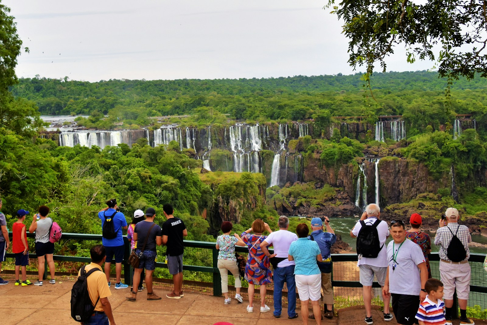 a group of people standing in front of a waterfall